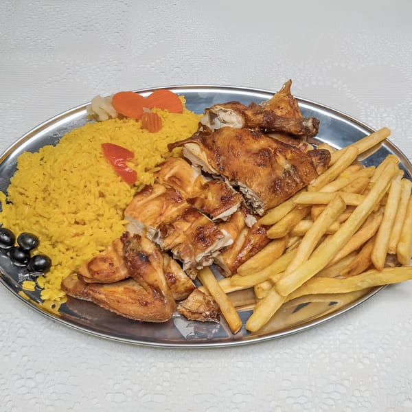 Fords BBQ platter with grilled chicken, yellow rice, french fries, and olives on a silver tray.